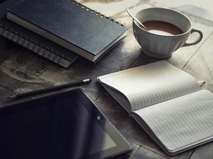 Image of Coffee Cup with Writing Pad on desk